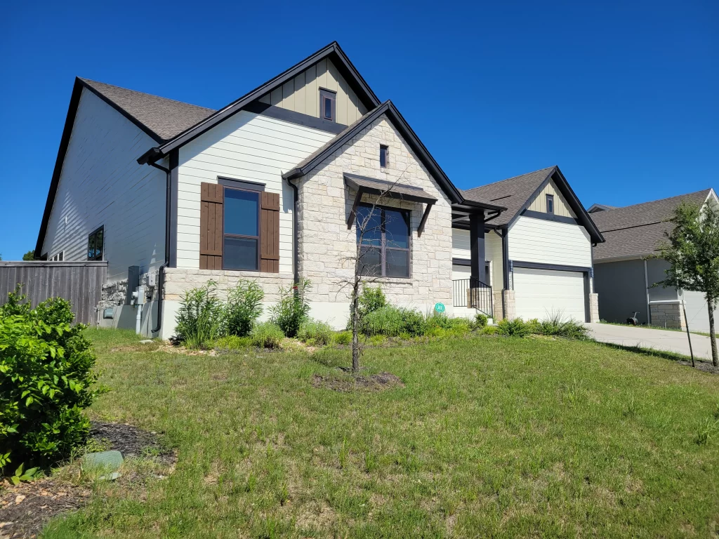 Exterior painting in Austin, TX showing freshly painted modern home with clean white finish and dark trim.